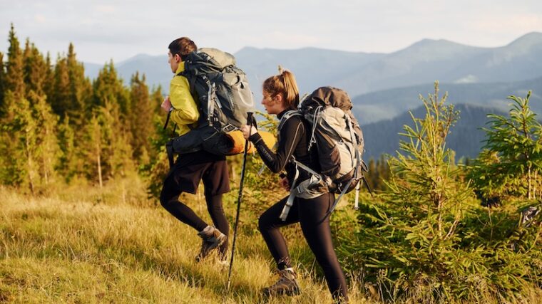 Två personer som är ute i naturen och vandrar