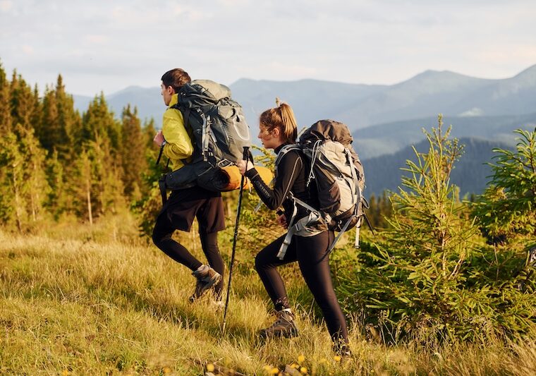Två personer som är ute i naturen och vandrar