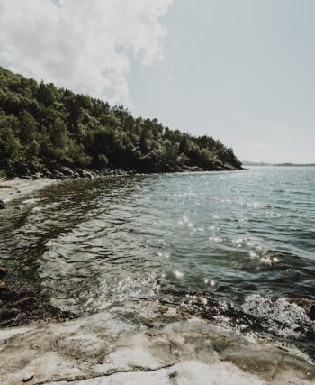 Bild på strand med redande berg runt