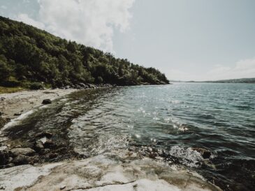 Bild på strand med redande berg runt