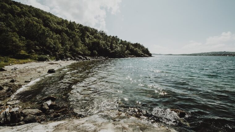 Bild på strand med redande berg runt